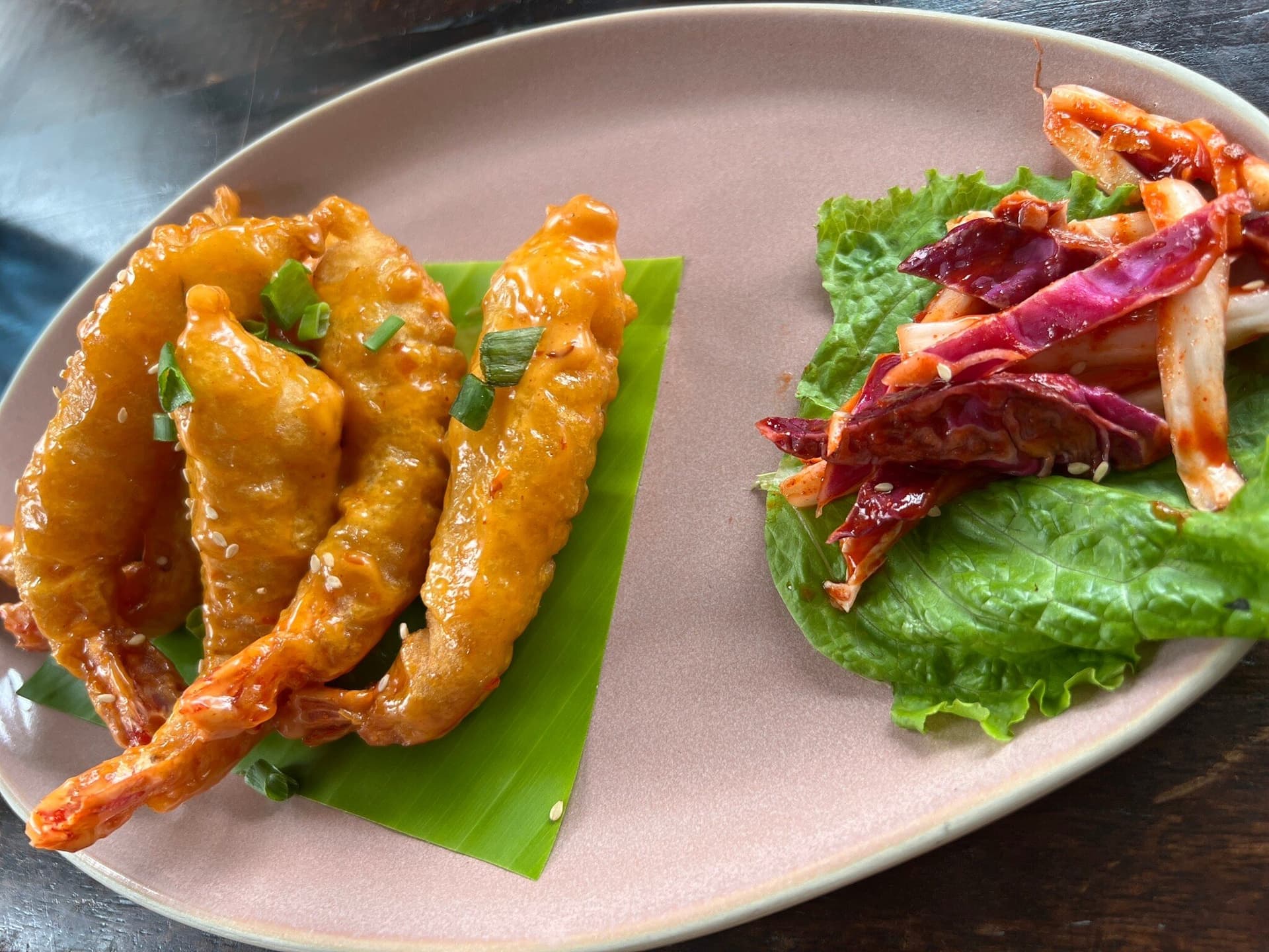 Glazed prawns and slaw on a rose plate